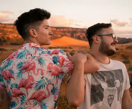 Two men posing for a photo holding and embracing each other.