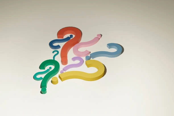 9 questions mark symbols on a table each with a different color.