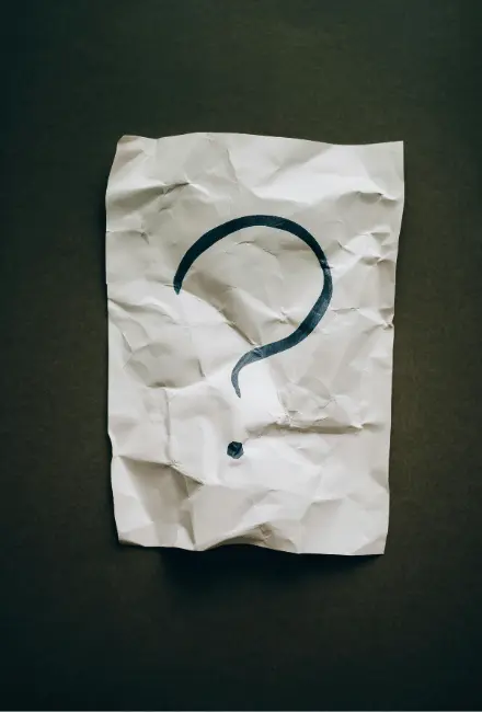 Crumpled white paper with large question mark drawn on it against dark background, representing common questions about bipolar disorder treatment