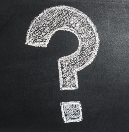 Large white question mark drawn or painted on dark chalkboard surface, representing questions about GAD therapy and treatment